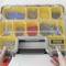 'Open compartment box with various screws and wall plugs in yellow sections. Two hands are holding the box.'