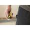A person is holding a yellow and black tape measure in their hand, ready for use, possibly for construction or renovation work.