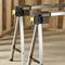 Two stable, yellow-black Stanley Fatmax sawhorses stand on a wooden construction site, ready to support building materials.
