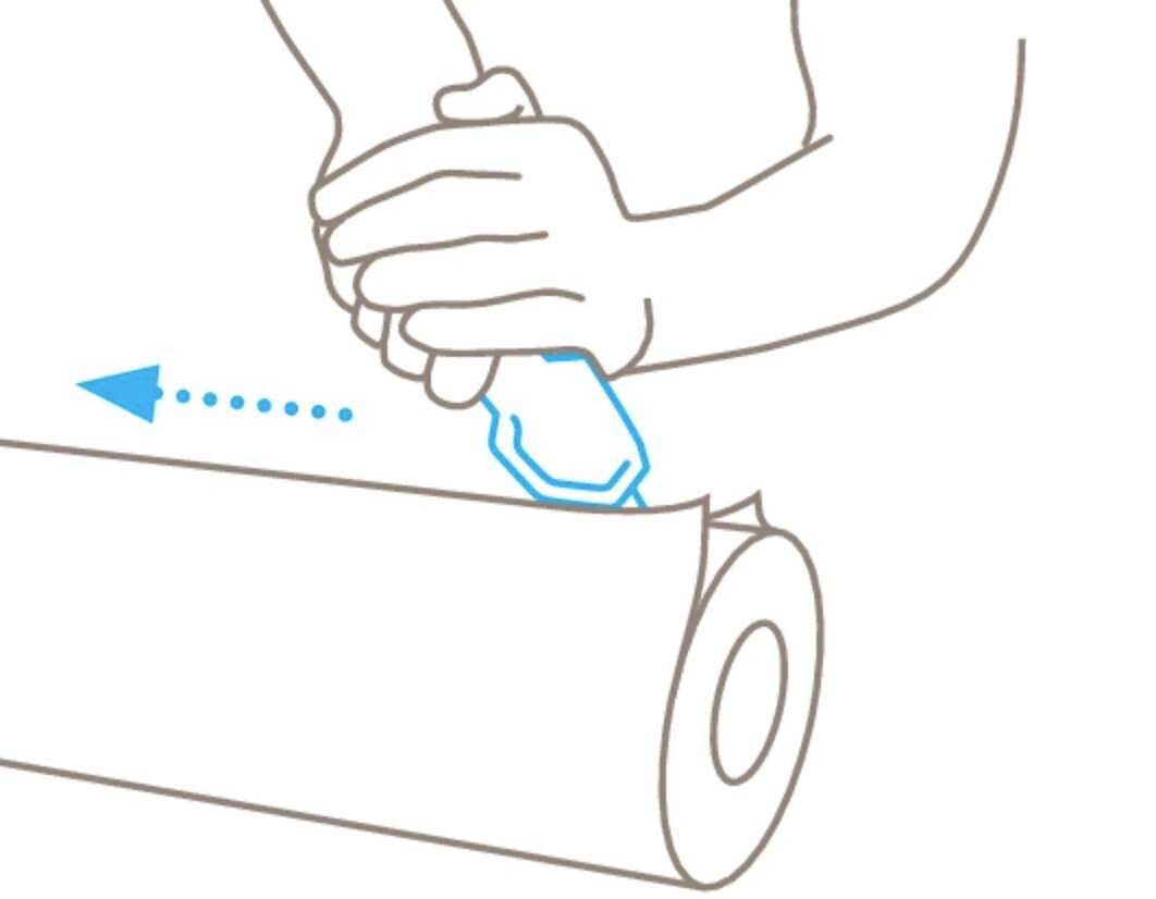 A person is using a tool to cut a paper roll. The arrow indicates the cutting direction is to the left.