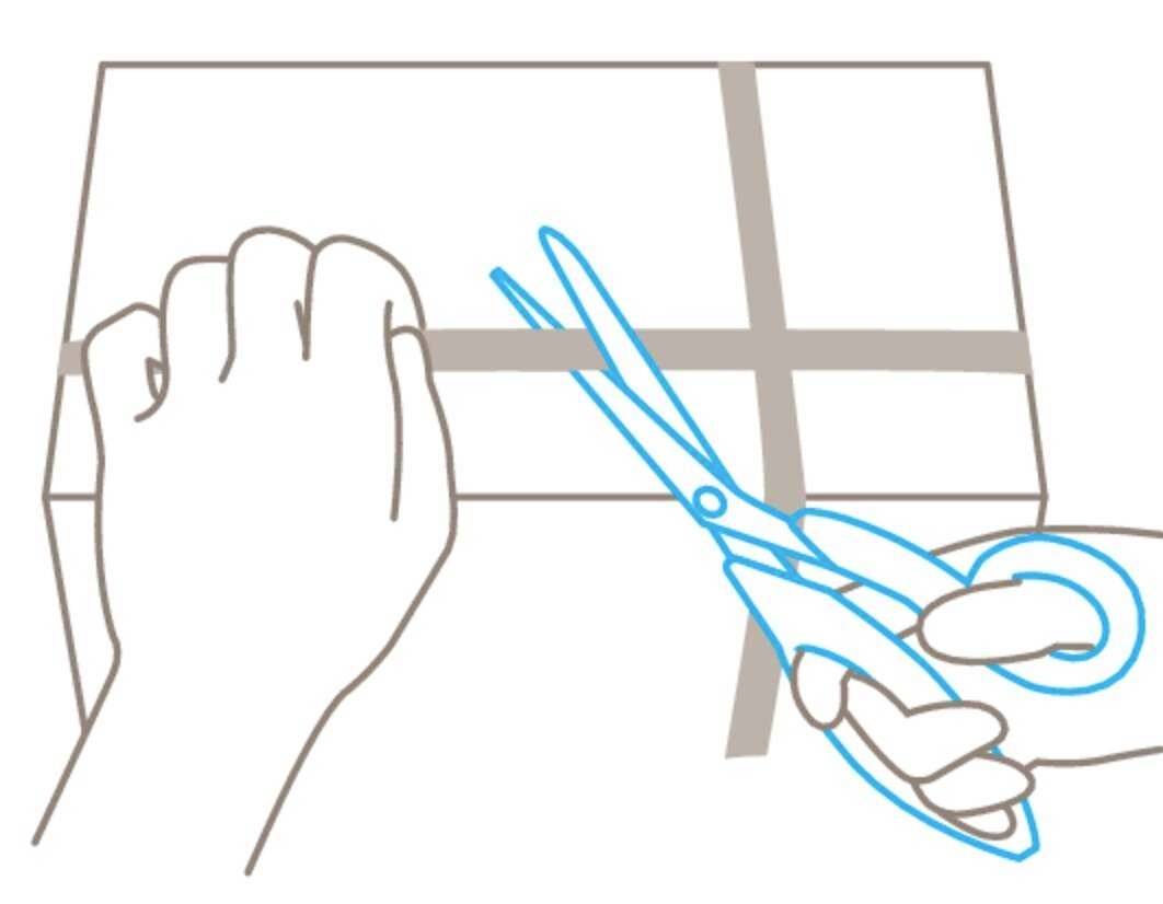A person is holding scissors to cut the ribbon on a package.