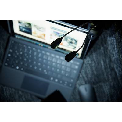 A laptop on a table, with its screen open. Two black USB lights are visible in front of the screen.