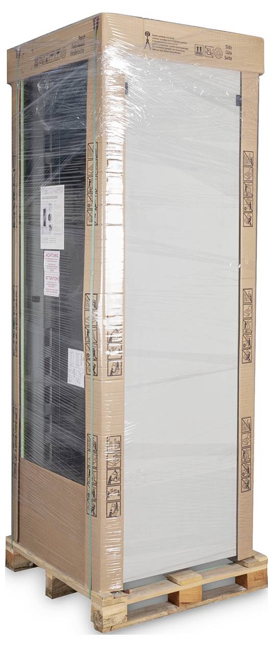 A large household appliance wrapped in cardboard and plastic film is standing on a pallet. It is secured for transportation.