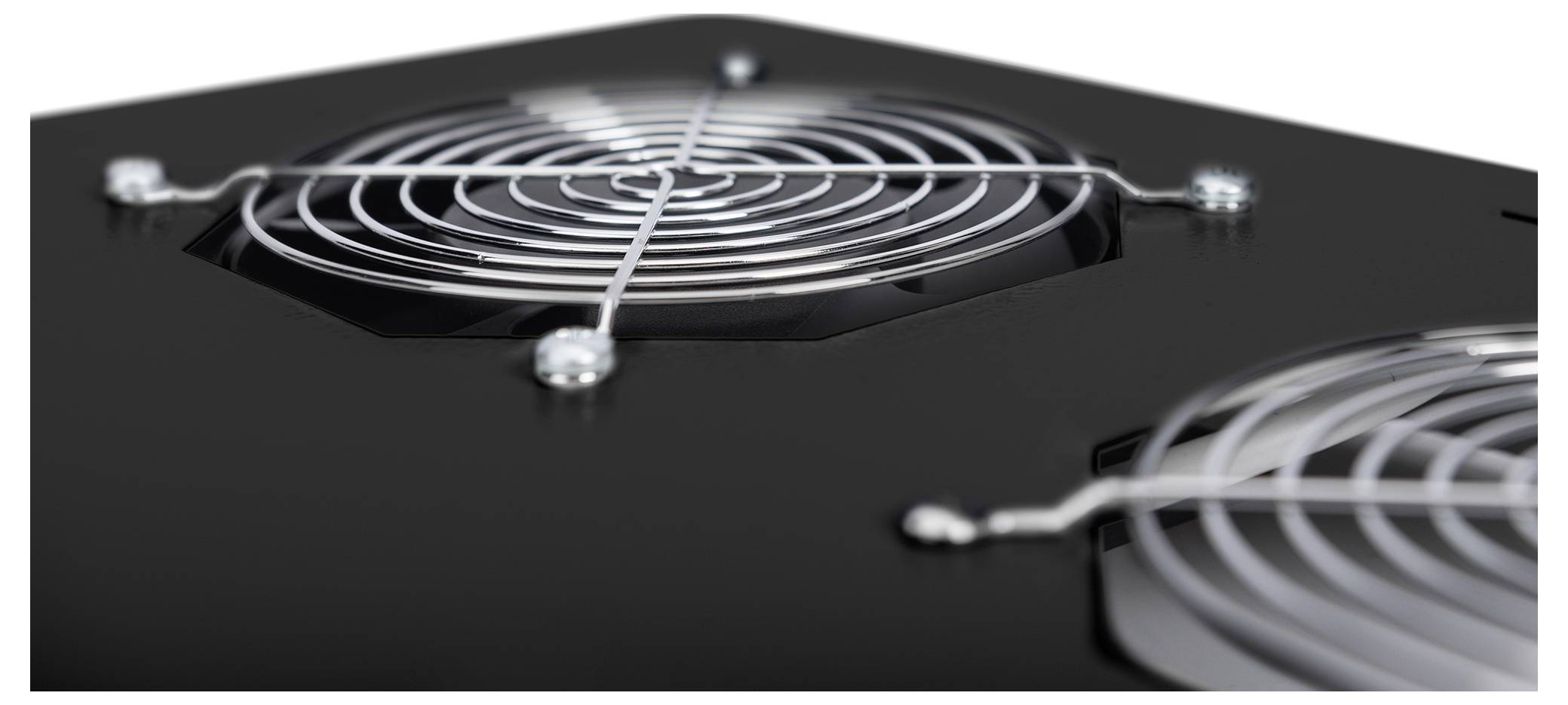 Close-up of two cooling fans with metal grills on a black surface, showcasing the design and structure of the ventilation system.