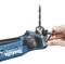 A person is inserting a drill bit into a drill machine. The drill bit has a blue casing with a brand inscription.