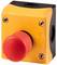 A red emergency stop button on a yellow housing. The button is used for rapid shutdown in emergency situations.