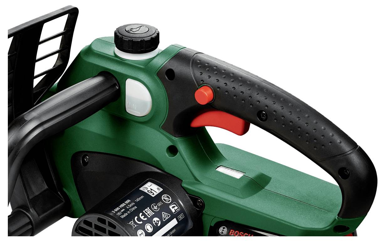Green and black handle of an electric garden tool with a red switch.