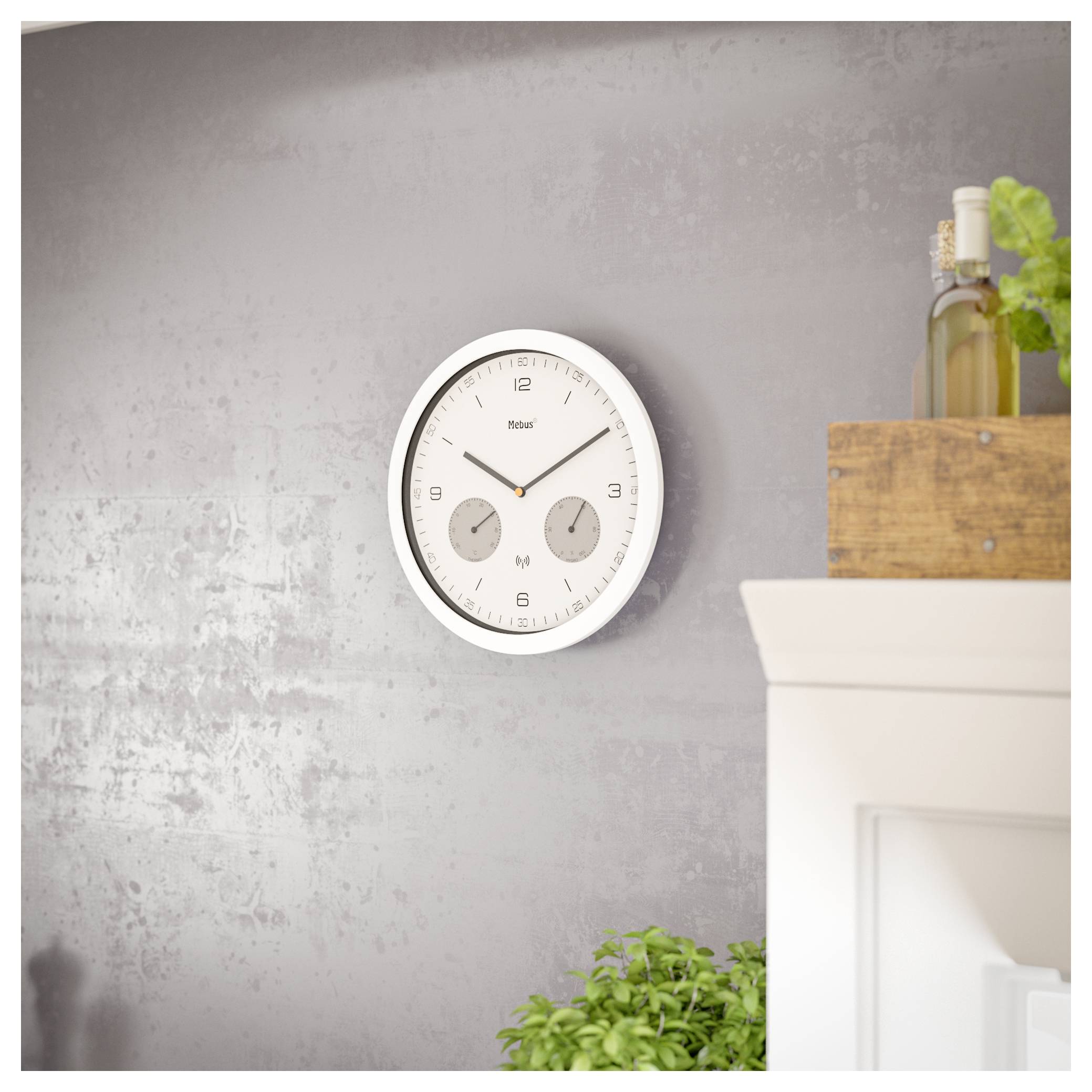 A modern white wall clock displaying 10:10 is mounted on a gray textured wall. Nearby are wooden shelves with bottles and green plants.