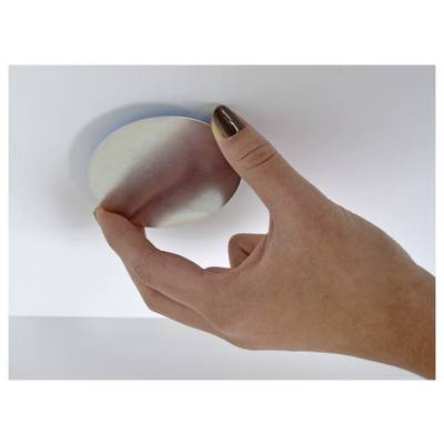 A hand presses a rounded white-and-pink stress ball against a white surface.
