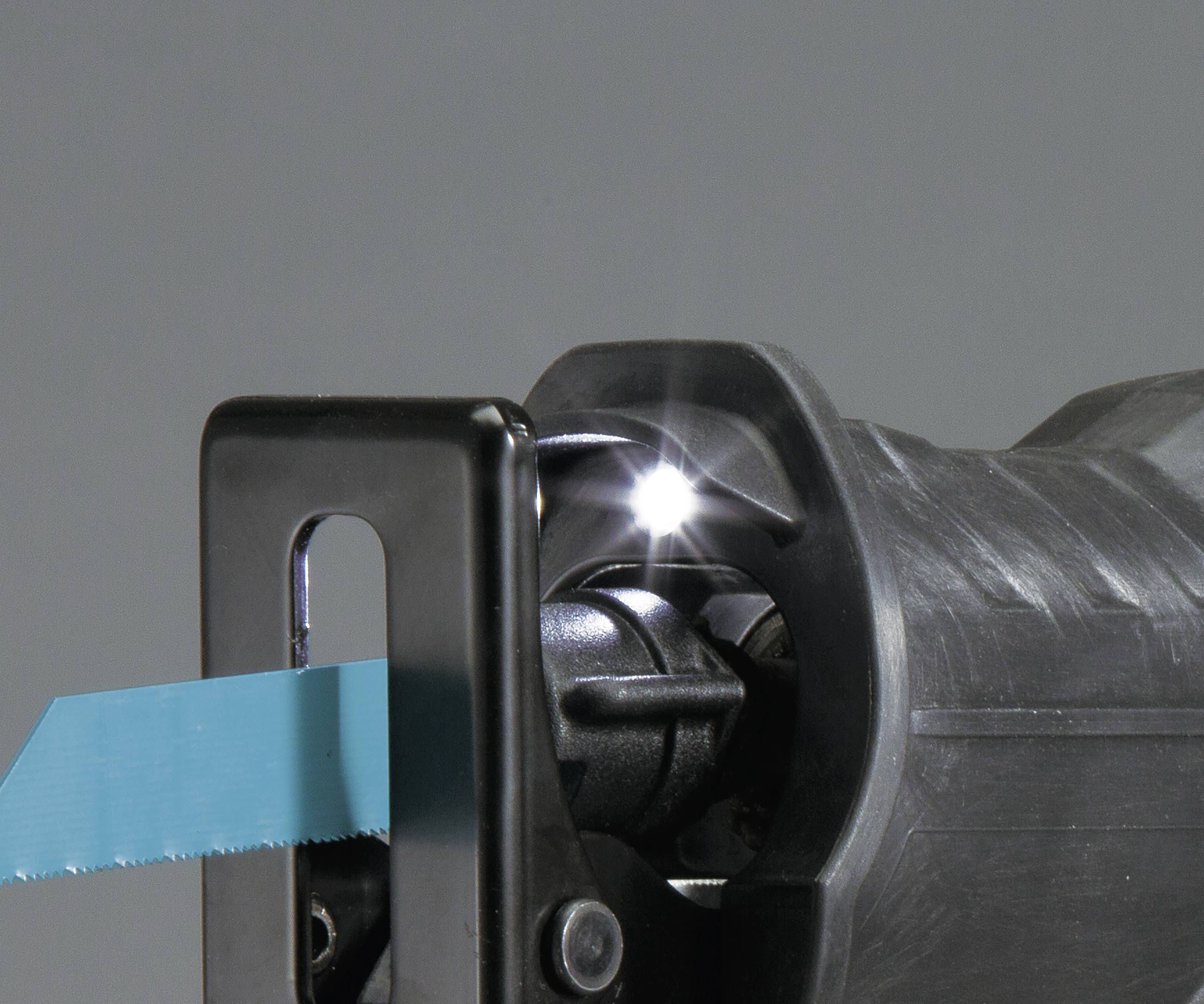 An electric saw cuts through a blue piece of wood or material. Sparks fly from the saw blade.