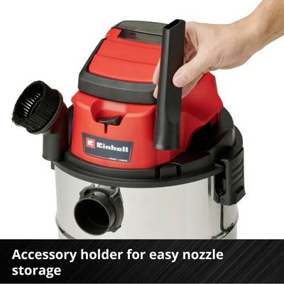 Vacuum cleaner with accessory holder; a hand inserts a nozzle. Function: easy storage of nozzles.