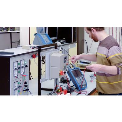 A man is working in a laboratory with electrical testing equipment and measuring instruments to verify technical functions.