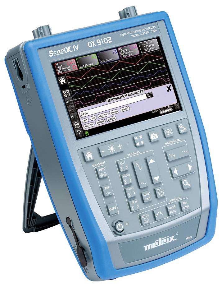 A portable oscilloscope with a display shows multiple waveforms and mathematical functions, with control buttons underneath.