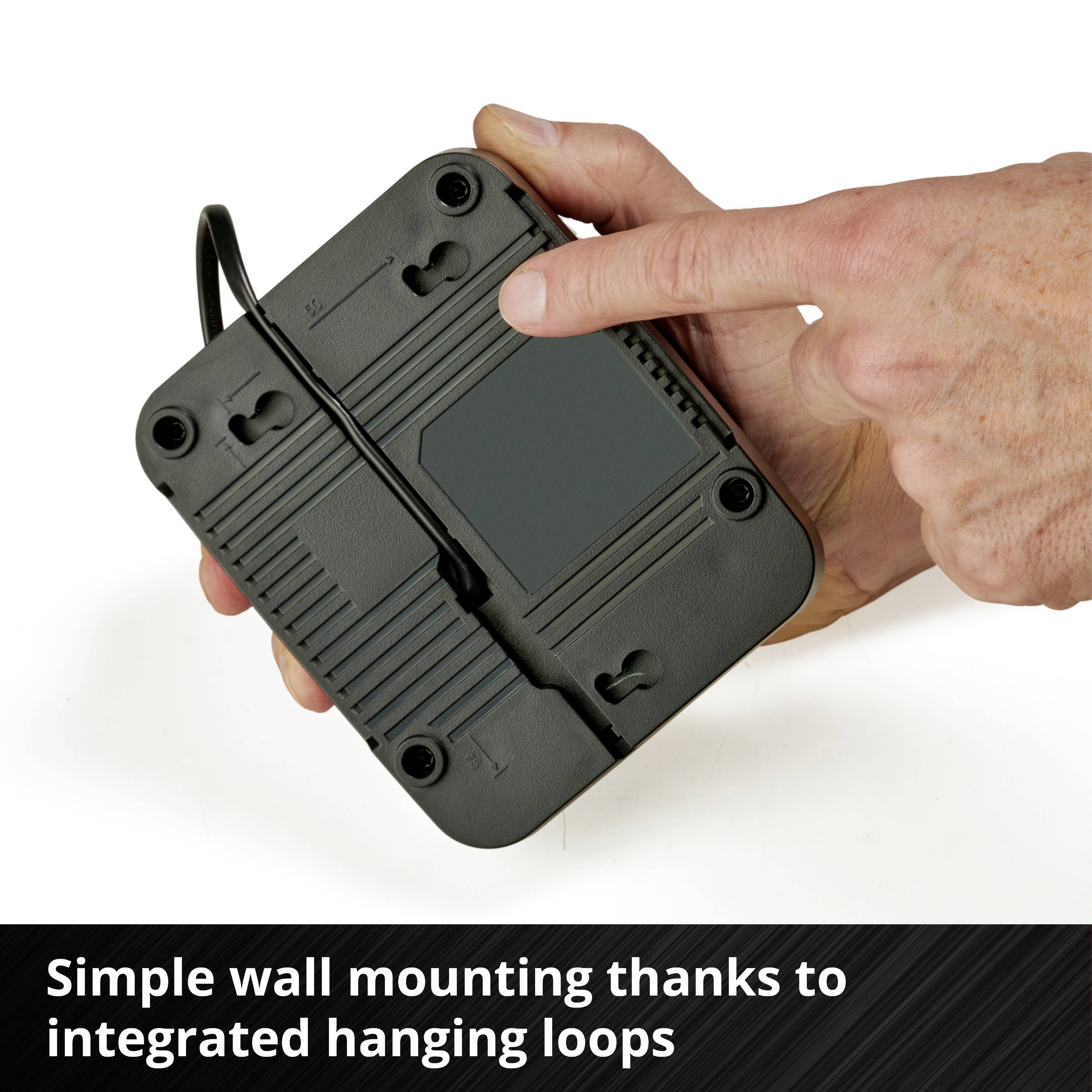 A hand is holding a device with cables and mounting loops. Text below: 'Simple wall mounting thanks to integrated mounting loops'.