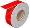A large roll of red adhesive tape with a glossy surface, partially unrolled.