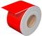 A thick, red ribbon of paper lies rolled up, with one end protruding upwards and showing a free edge.