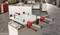 A workpiece is secured with multiple clamps on a table in a workshop. The background shows a workbench and shelves.
