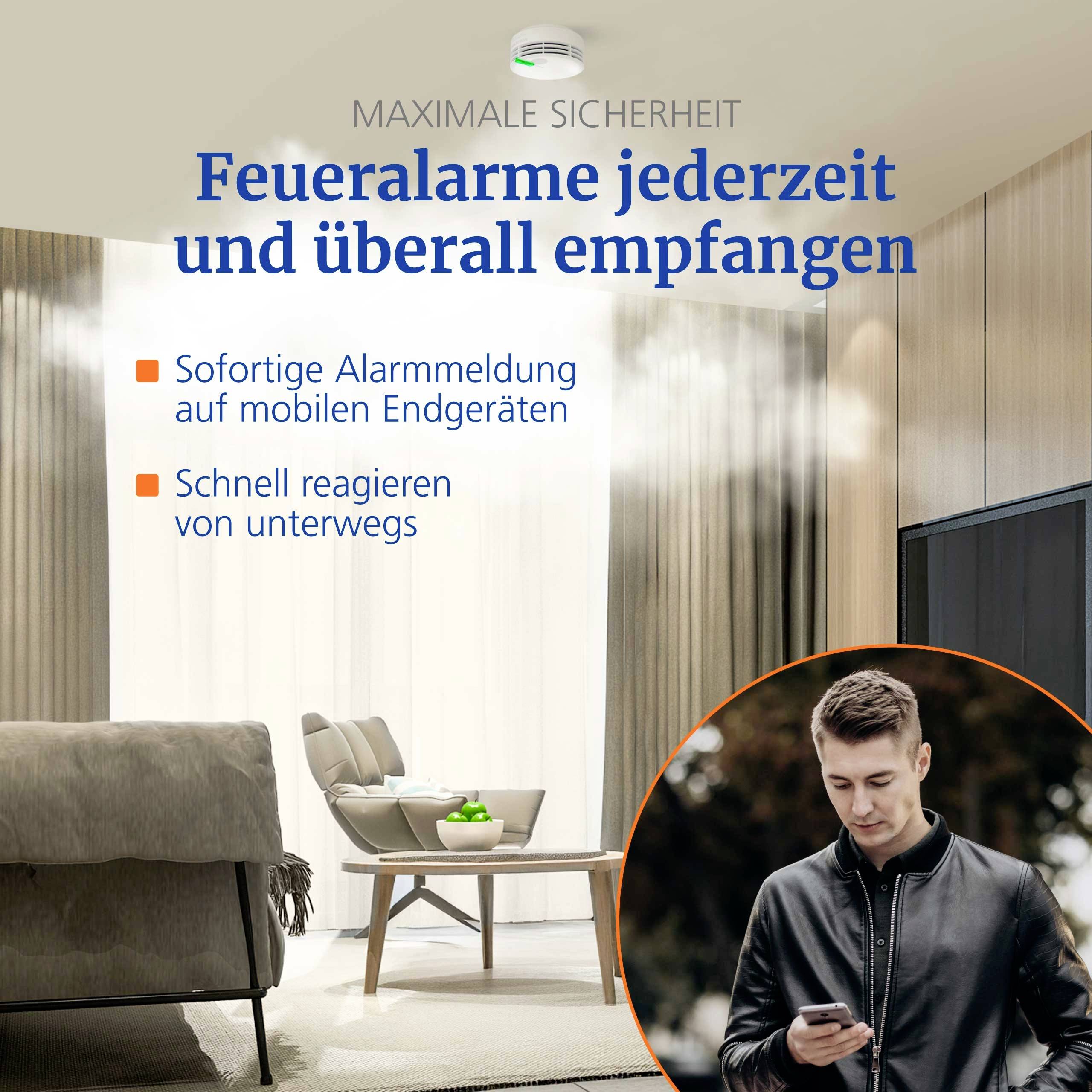 A man holding a smartphone is in a room with a smoke alarm, orange glow lights, and German text about receiving fire alarms anytime.