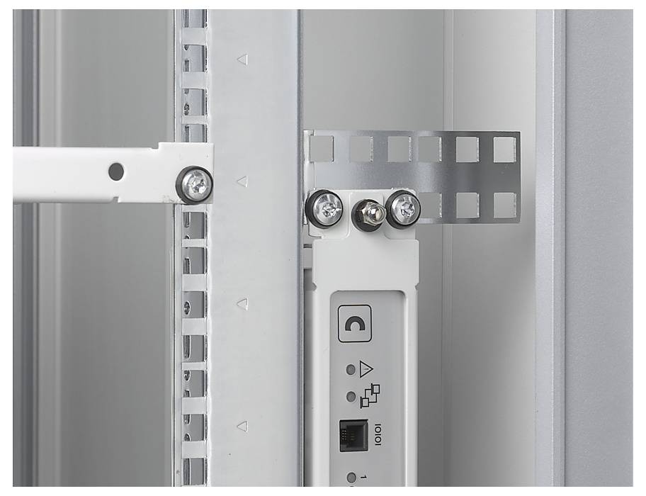 Close-up of a metal cabinet hinge with screws, showing a small section of a white electronic component with connections.