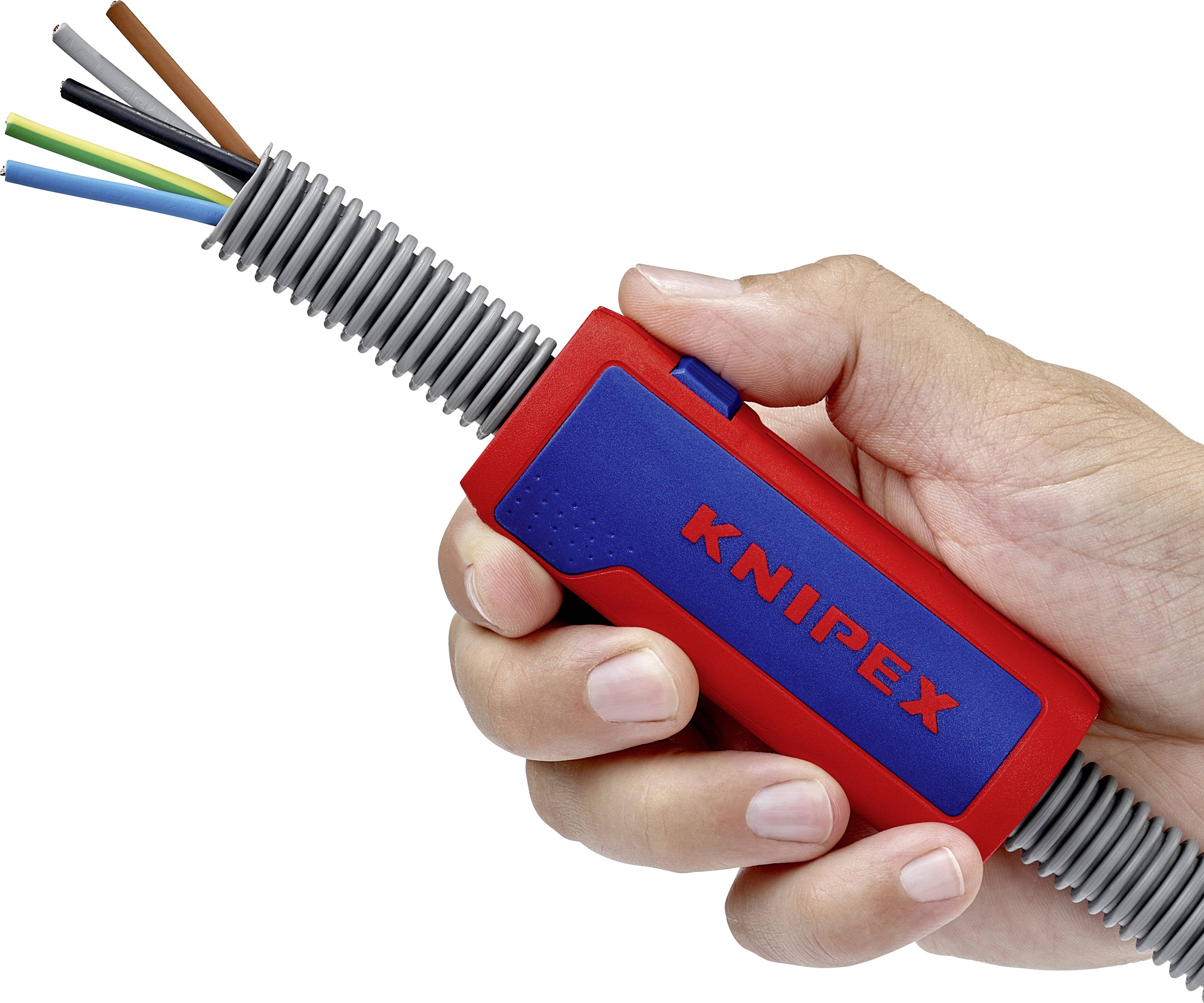 A hand is holding a Knipex tool to guide cables within a cable protection conduit.