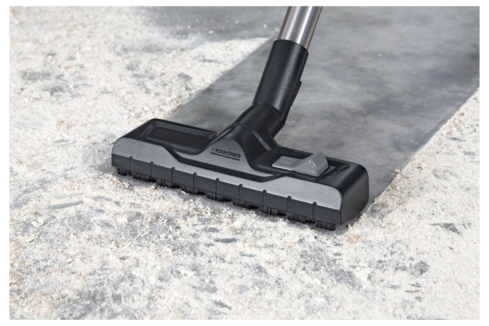 A vacuum cleaner nozzle is seen effectively removing dust and debris from a carpeted floor, demonstrating cleaning power.