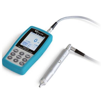 Ultrasonic hardness tester with blue casing and separate sensor. Display shows hardness measurement results. Device used for material testing.