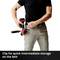 A person clips a tool to their belt to keep it readily accessible. The focus is on the handling of the tool.