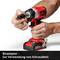 A person is using a red cordless screwdriver with a bit adapter, suitable for screw fastening work.