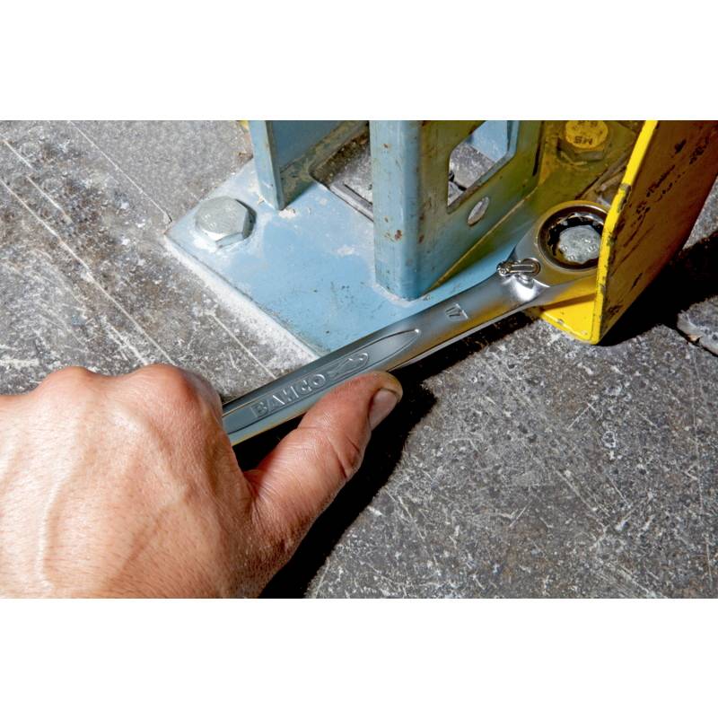 A hand uses a wrench to tighten a bolt on a metal structure.