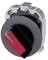 A round industrial switch in profile with a red lever and black housing, against a grey background.