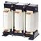 'A three-phase transformer with three windings in a metallic frame, used for voltage adjustment in electrical systems.'