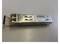 A Siemens SFP module is lying on a table. It is used to connect network devices and is rectangular with a metal housing.
