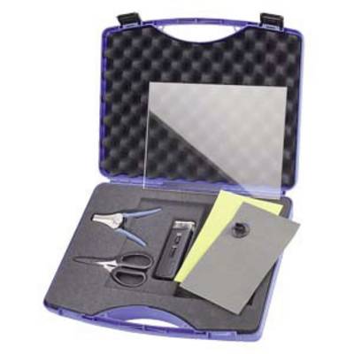 An open suitcase with foam lining, containing a pair of pliers, scissors, a rectangular transparent sheet, a yellow sheet, and a grey object.
