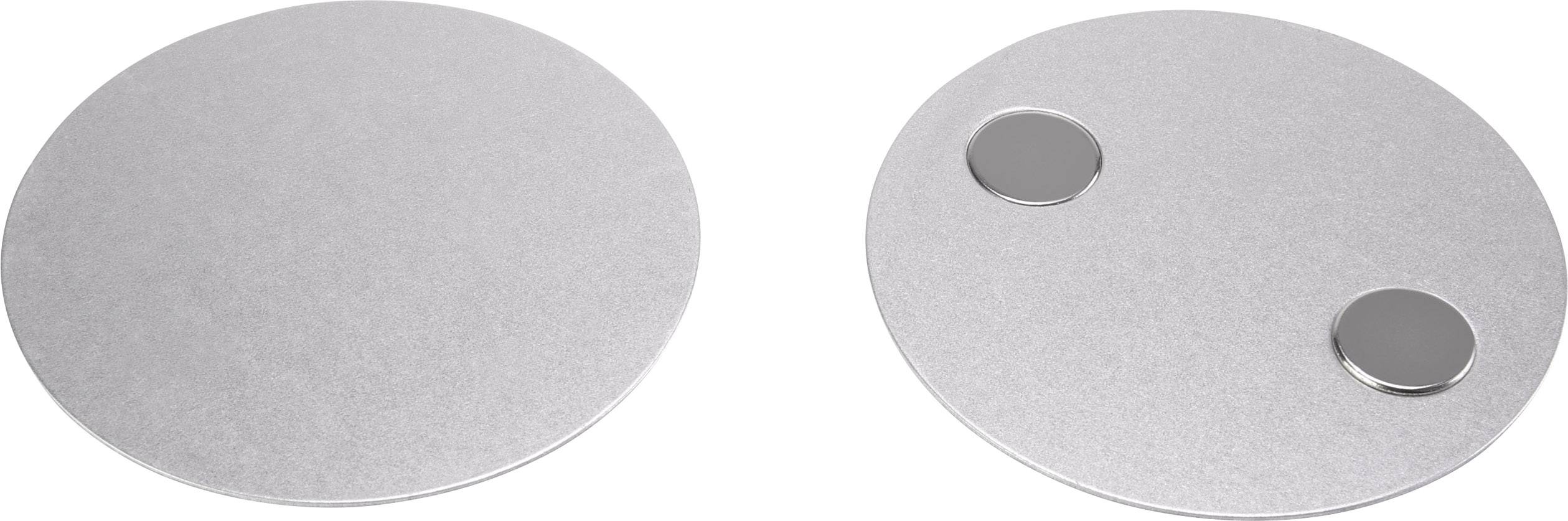Two round, metallic objects: on the left a smooth disc, on the right a disc with two small, round magnets.