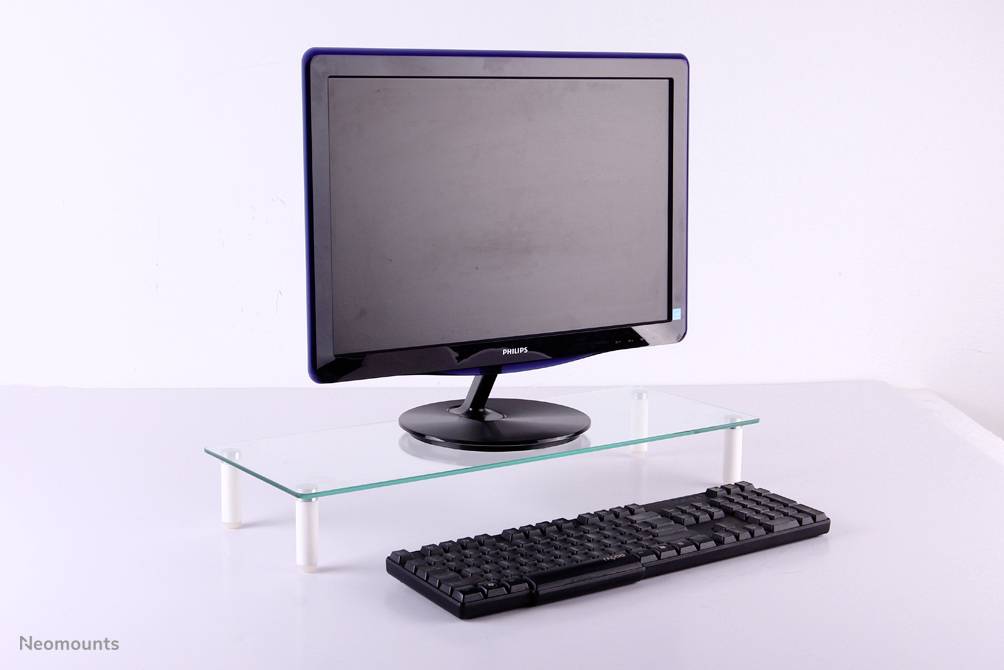 Computer monitor and keyboard on a desk with a glass shelf, against a white background.
