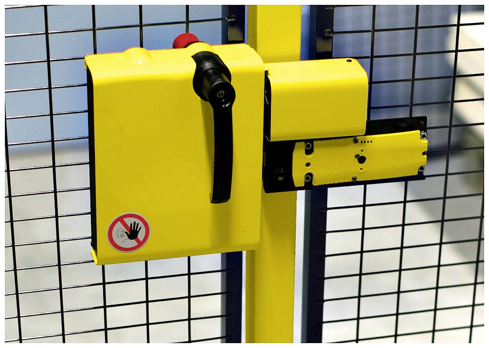 Yellow mechanical lock on a metal grid with a warning symbol of a 'hand prohibited' sign, red emergency stop button at the top.