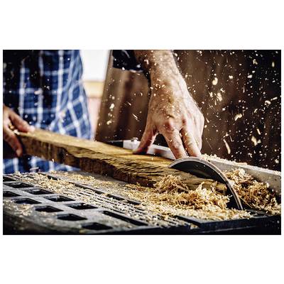 A person is cutting a wooden board with a circular saw, surrounded by wood shavings. Focus on safety and precision.