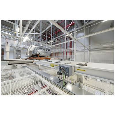 A car factory where an incomplete car is being moved along an assembly line. Metal structures and lighting are visible.