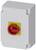 Grey electrical cabinet with a red emergency stop switch on a yellow background, used to interrupt the power supply.