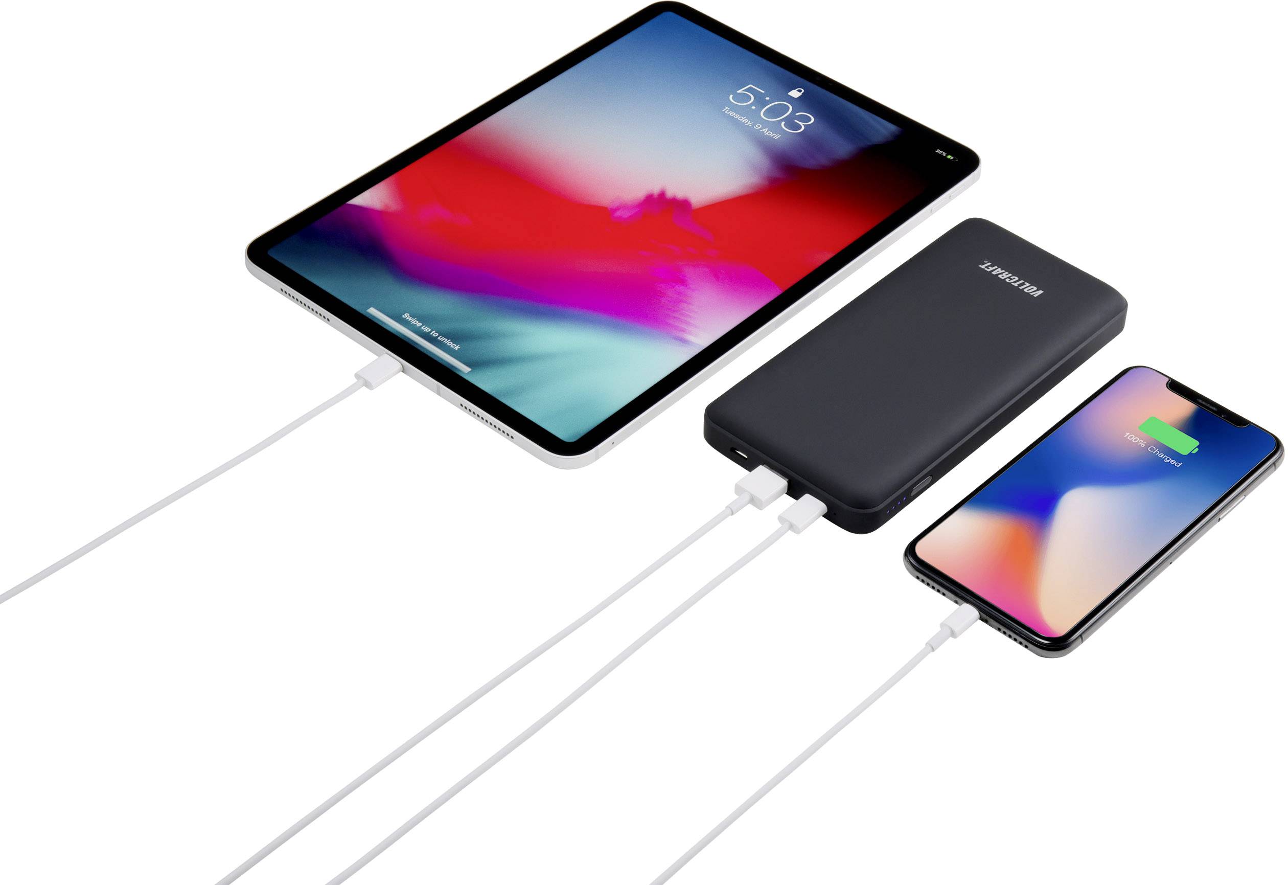 A tablet and a smartphone are connected to a battery charger and are being charged. The smartphone displays a charging icon.