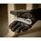 A gloved hand holds a robust pocket knife with the inscription 'Stanley', against a blurred background.