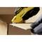 A person is carefully cutting open a cardboard box with a yellow Stanley utility knife.