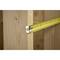 A tape measure is placed against a wooden frame, possibly for measuring during construction or renovation work.