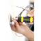 A person is mounting a metal plate on the wall using a yellow and black screwdriver. Cables are visible in the background.