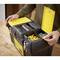 A person opens a toolbox on a wooden table, filled with yellow and red wall plugs and metal components.