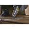 A person is cutting through a cardboard box with a utility knife. They are wearing protective gloves.