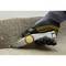 A tradesman wearing protective gloves is cutting a carpet with a utility knife.