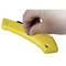 A person is holding a yellow utility knife with their thumb on the sliding mechanism.