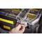 A hand opens the fastener of a black toolbox with a transparent lid, yellow handle, and compartments for screws.