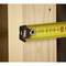 A yellow tape measure shows a measurement of approximately 6.8 cm on a light wooden board, highlighted by sharp focus.
